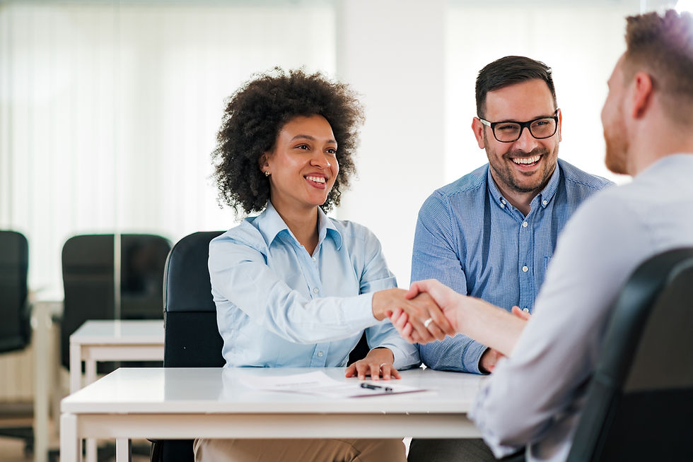 Woman shaking a man's hand across a desk