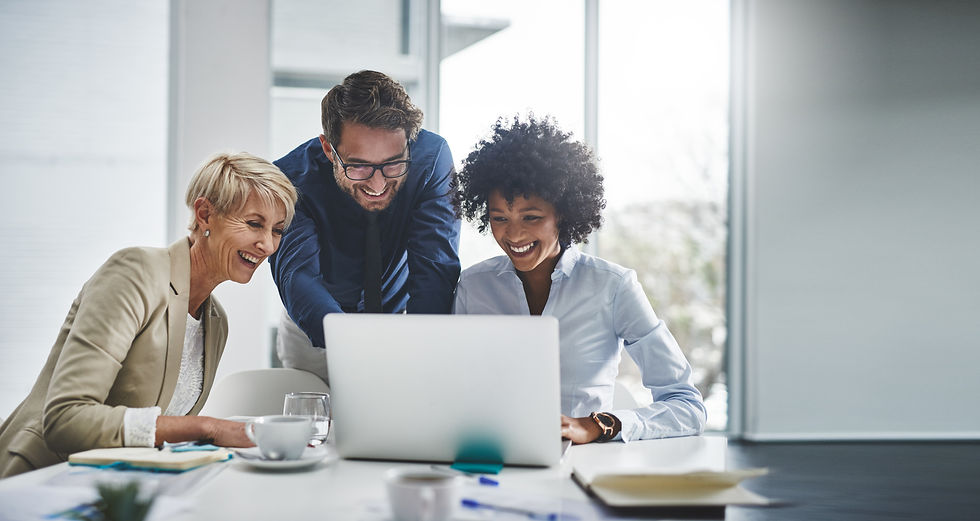 three coworkers looking at a laptop